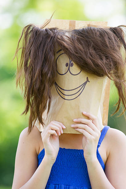 istock Girl holding empty bag with smiling face on it 530698155