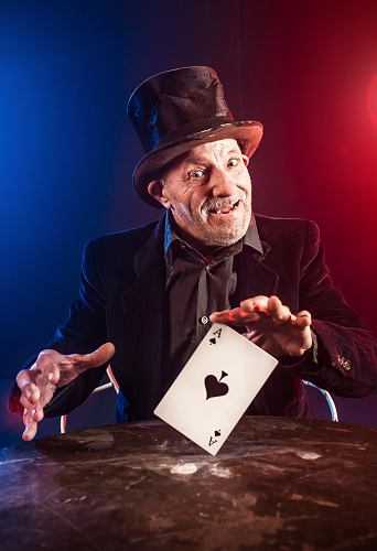 Crystal ball fortune teller with hands hovering over with wood base on black background