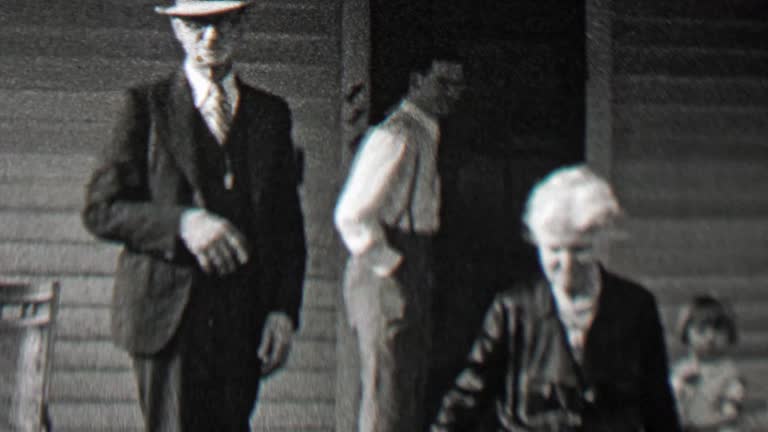 1938: Family welcomes visitors on front porch man waves hello.