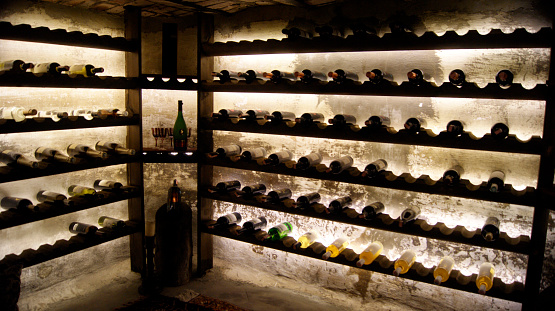 Image of a wine cellar in basement area. Soft back light behind the wine racks creates an ambiance to the image.