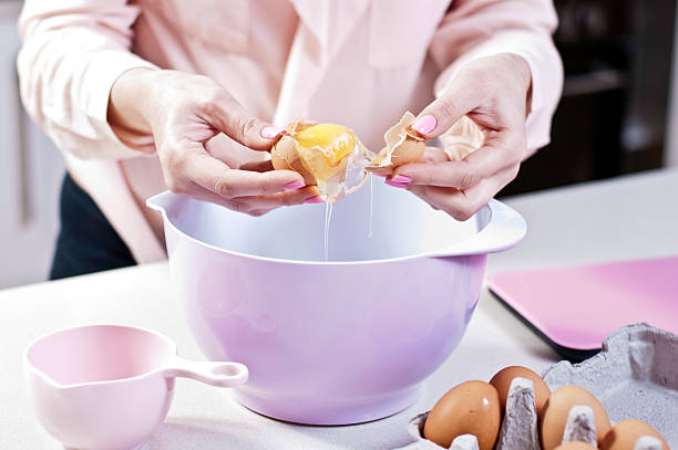 istock Cracking an Egg into Mixing Bowl in pink themed Kitchen 530708941