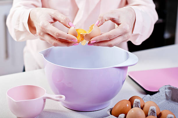 istock Cracking an Egg into Mixing Bowl in pink themed Kitchen 530708943