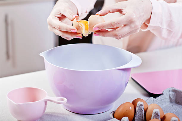 istock Cracking an Egg into Mixing Bowl in pink themed Kitchen 530708945