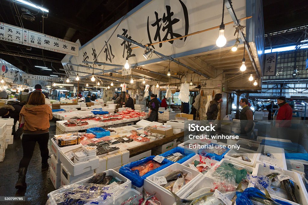 Tsukiji Fish Market in Tokyo, Japan Tokyo, Japan - December 22, 2014 : People at the Tsukiji Fish Market, it is the biggest wholesale fish and seafood market in the world. The market is located in central of Tokyo, and is a major attraction for foreign visitors.  Business Stock Photo