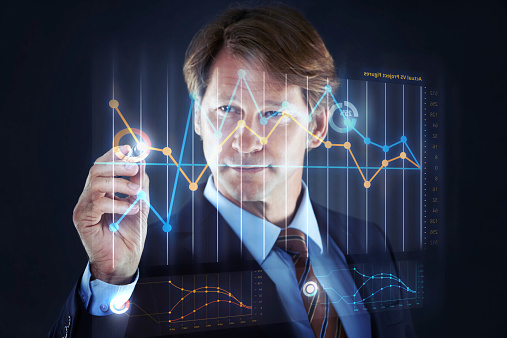 Cropped shot of a businessman writing on a hologram chart.All screen content is designed by us and not copyrighted by others, and upon purchase a user license is granted to the purchaser. A property release can be obtained if needed.