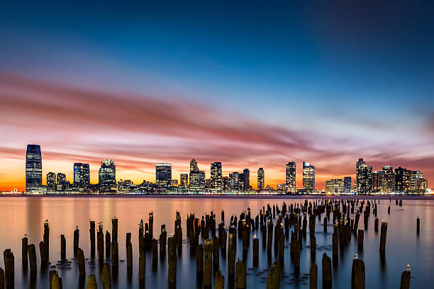 Jersey City skyline at sunset Jersey City skyline at sunset as viewed from Tribeca, New York across the Hudson River jersey city stock pictures, royalty-free photos & images
