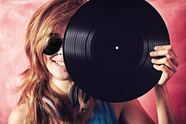 Fun portrait of a young woman holding a vinyl record up to her facehttp://195.154.178.81/DATA/shoots/ic_781190.jpg