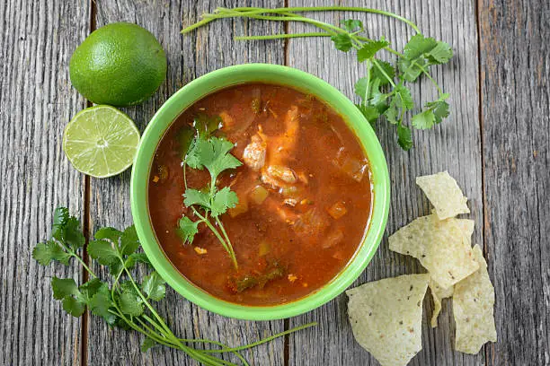 Photo of Tortilla Soup with Cheese, Lime, Cilantro and Wooden Spoon