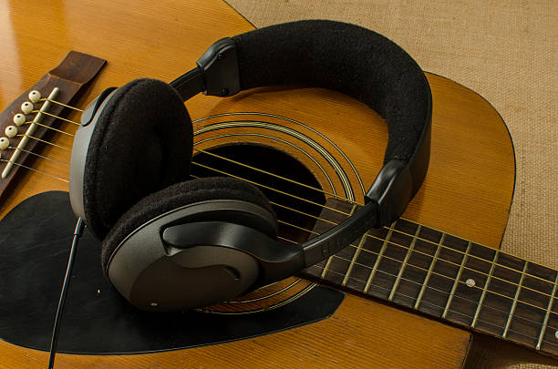 istock Old acoustic guitar with headphones 530718437