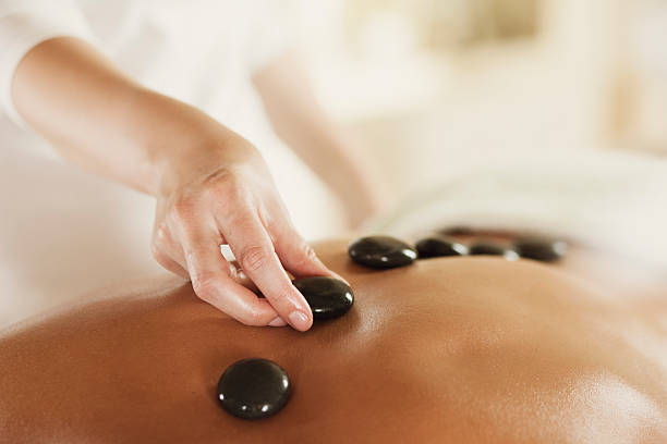 la terapia de piedras calientes de masajes - massage stones fotografías e imágenes de stock