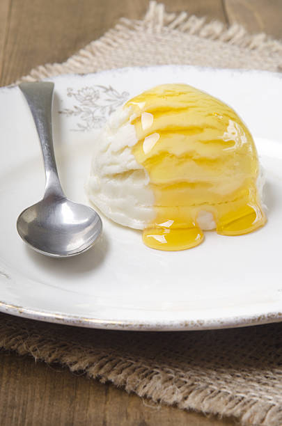 vanilla yogurt ice cream with acacia honey and spoon on a plate