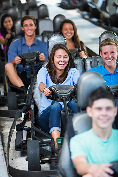 istock Group of teens at amusement park on gocarts 530730465