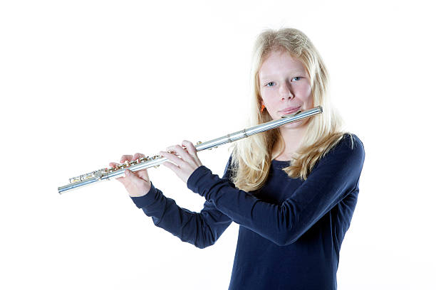 istock young blond girl playing flute in studio 530730685