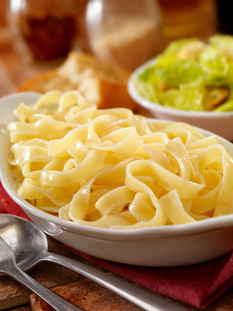 Fettucini in a Garlic Butter Sauce Fettucini in a Garlic Butter Sauce with fresh Mozzarella, Parmesan cheese, Caesar Salad and Garlic Bread -Photographed on Hasselblad H3-22mb Camera cooked selective focus vertical pasta stock pictures, royalty-free photos & images