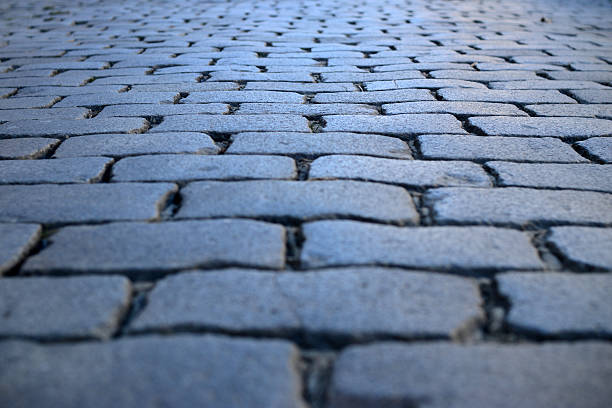 Grey cobblestone textured floorof Roman Way in Paris in the evening