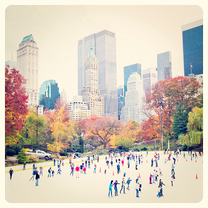 Ice skaters having fun in New York Central Park in fall with Instagram effect filter