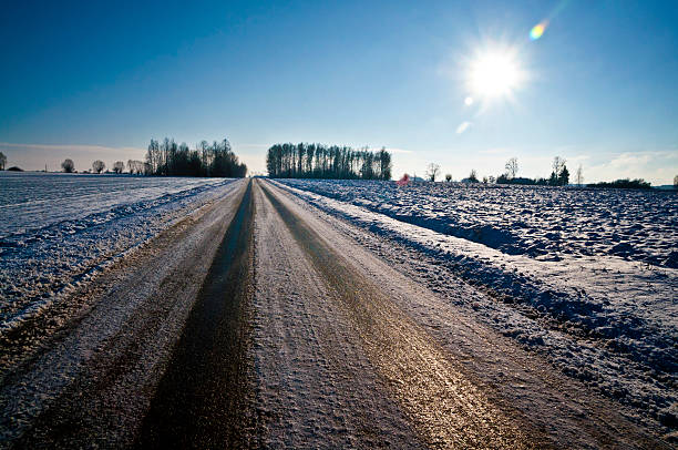 Black ice in a winter time on a sunny day - slippery unsafe country road