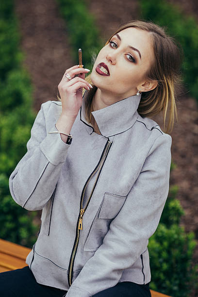 istock Young woman smoking cigarette on the bench 530741278