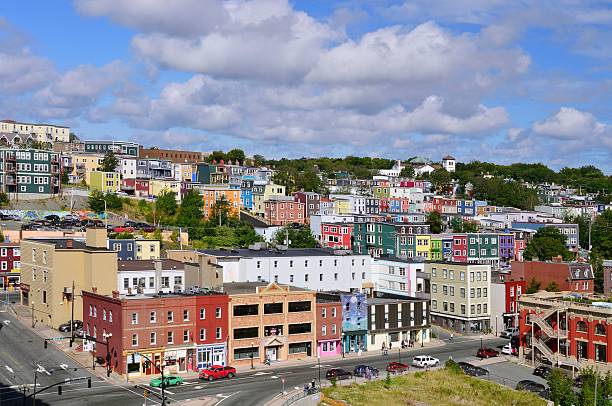 St John's Newfoundland Jelly Bean Houses A bright afternoon shows off the Jelly Bean houses in St. John's Newfoundland as they rise up the hillside from Water Street to a blue sky punctuated by fluffy cumulus clouds st. johns newfoundland photos stock pictures, royalty-free photos & images