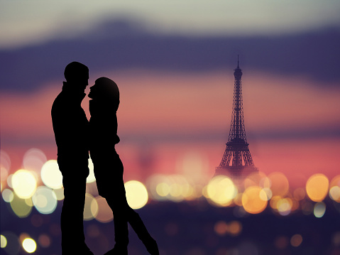 silhouette of romantic lovers with eiffel tower on a background in Paris , Franceabstract background : silhouette of romantic lovers with eiffel tower in Paris with sunset