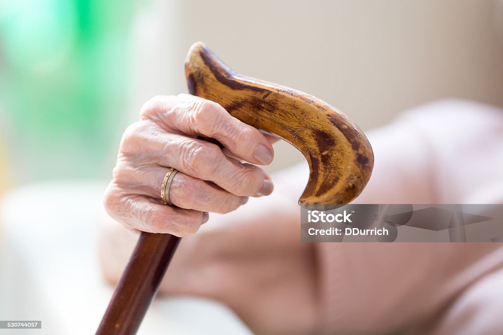 Senior woman hand senior woman's hands holding her walking stick Close-up Stock Photo