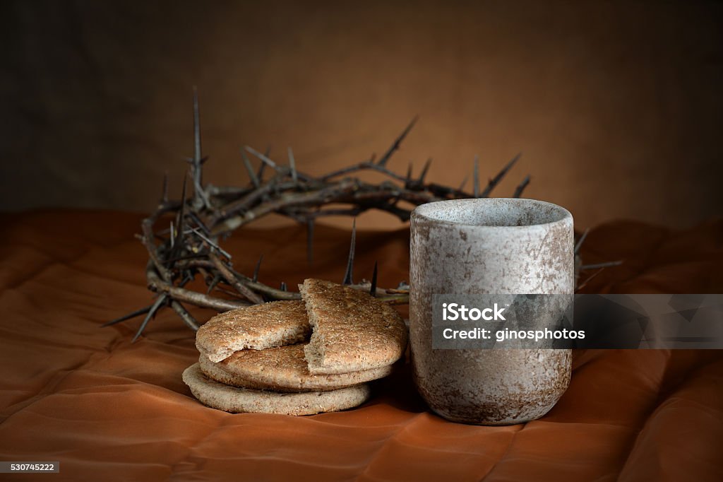 Communion Cup and Bread Communion cup and bread with crown of thorns in background Communion Stock Photo