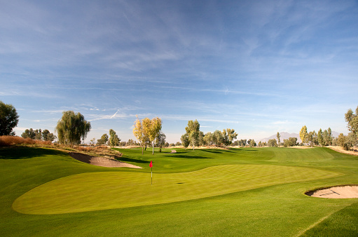 A beautiful golf course in Arizona, United States. This beautiful desert golf course is located near Phoenix and, perhaps, the golf capital of the American Southwest, Scottsdale. Desert golf is one of the most popular genres of the game and this part of the world is one of the best places to play resort golf - with a desert motive - in the world. Nobody is in this golf course scenic image, which features beautiful green turf and a wonderful blue sky. 