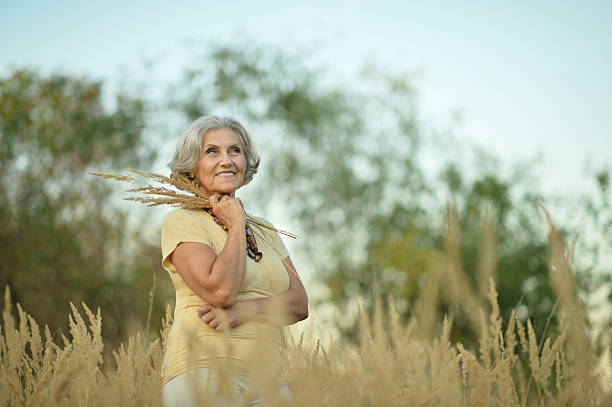 istock senior woman in summer field 530748646