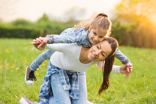 istock Mother and her daughter siting on the grass 530752102