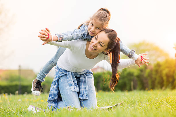istock Mother and her daughter siting on the grass 530752234