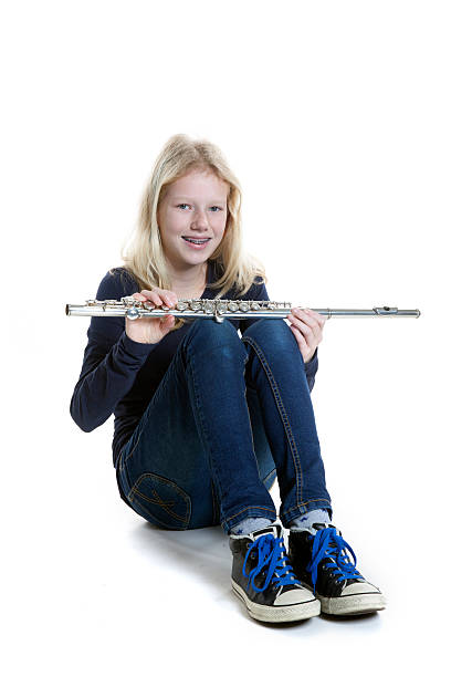 istock young blond girl sits and holds flute in studio 530753625