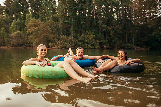 istock Happy young adults on inner tubes in lake 530754854