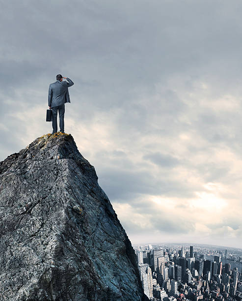istock Businessman Looking At Big City While Standing On Mountain Top 530755956