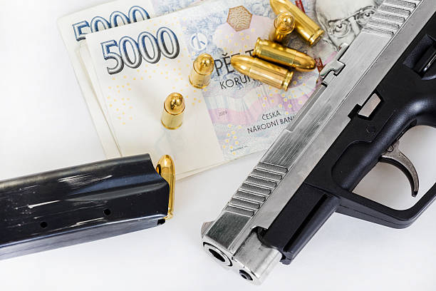 istock gun with bullet on czech banknotes 530756153