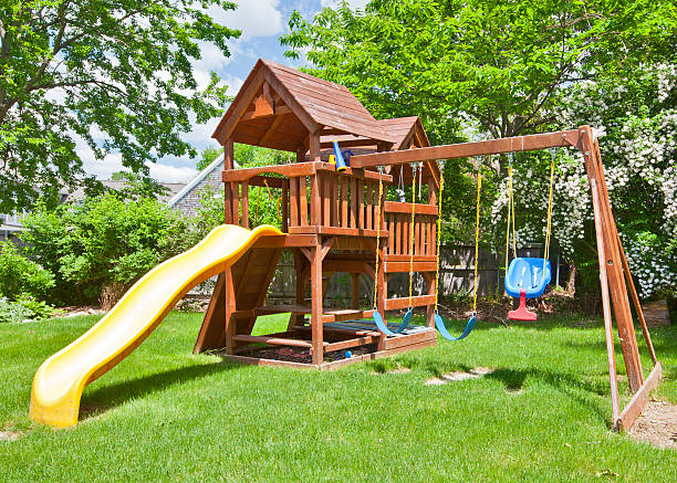 Swing Set Back Yard Wooden Swing Set on Green Lawn swing play equipment photos stock pictures, royalty-free photos & images