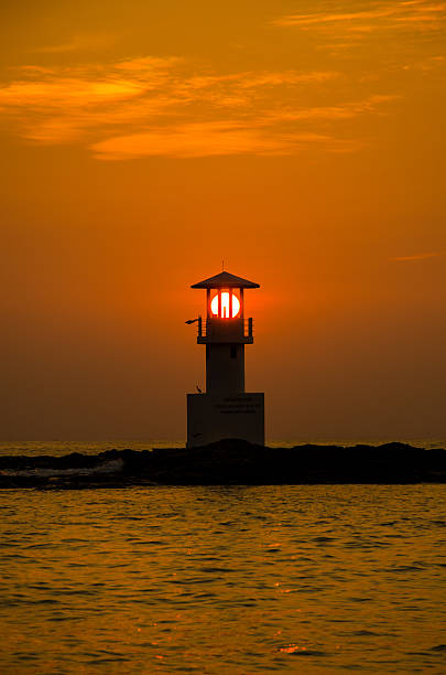istock Silhouettes of lighthouse at sunset. 530758596