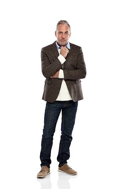 Thoughtful mature man looking at camera Studio shot of thoughtful mature man in casual wear looking at camera over white background worried man standing stock pictures, royalty-free photos & images