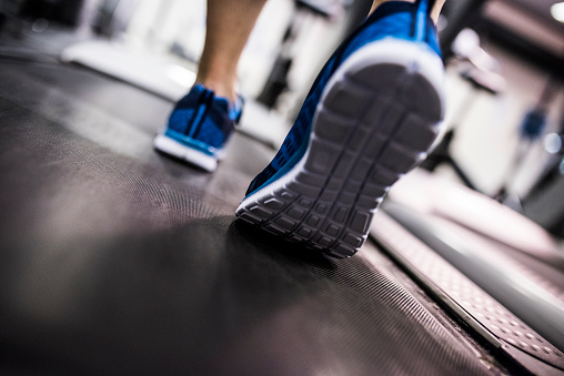 Close up of woman's feet on a treadmill at the gym.