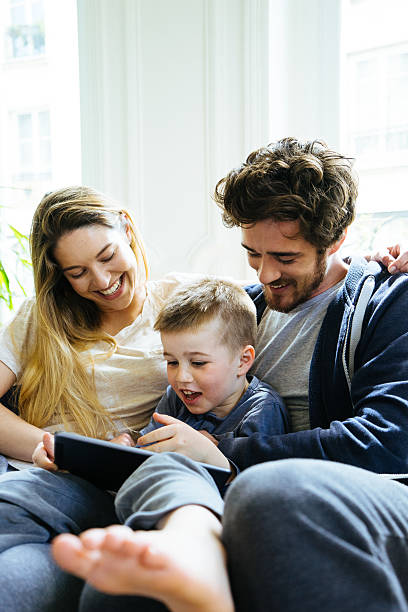 istock Cheerful Young Family Looking At Digital Tablet Together 530762470