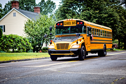 Yellow school bus driving along street