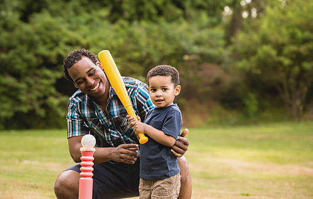 Afro-americana, Padre e figlio giocando a palla all’aperto - foto stock