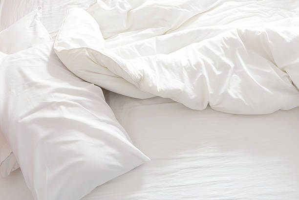 vue du haut de l'unmade lit avec froissé drap de lit. - pillow hotel bed sleeping photos et images de collection
