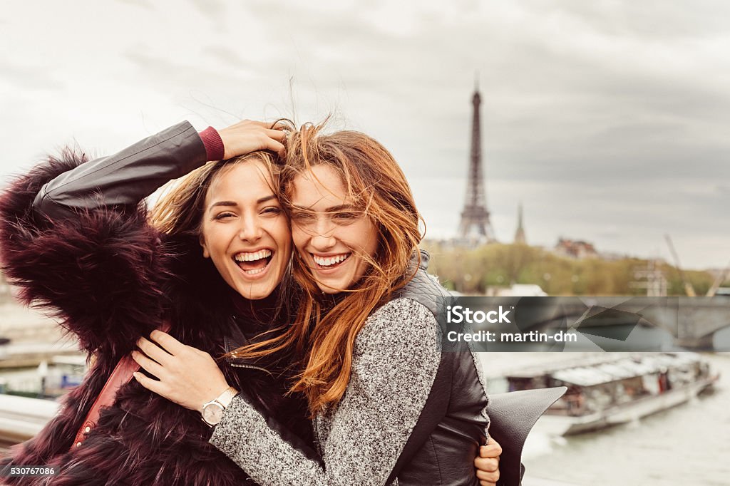 Happy girls in Paris against the Eiffel tower Happy girls on a vacation in Paris Friendship Stock Photo