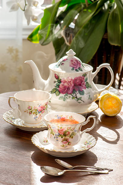 старинный стол, послеобеденный чай в теплых солнечных лучей. - afternoon tea china antique cup стоковые фото и изображения