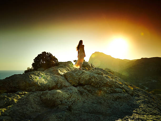 istock Woman silhouette at sunset in mountains 530770231
