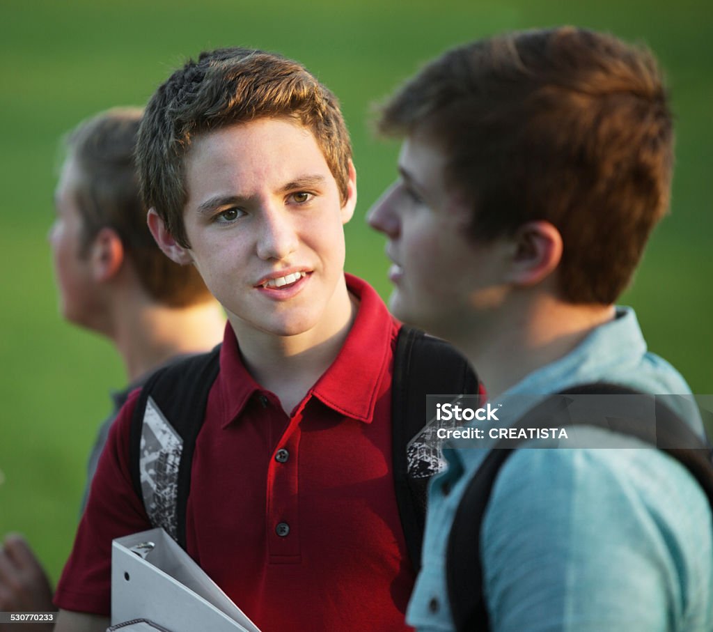 Two Teen Boys Talking Two teen white male students talking outdoors Backpack Stock Photo