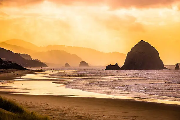 Tranquil warm seascape during late morning with the iconic haystack rock on the right.