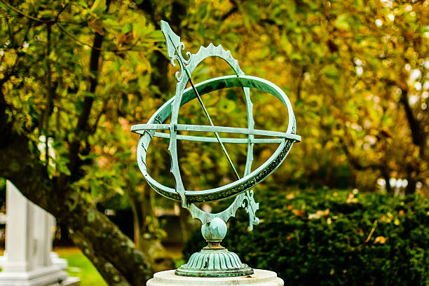Sundial Mounted turquoise sundial in landscaped park setting. tressle stock pictures, royalty-free photos & images