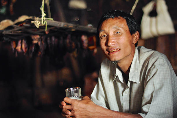Aoleang, Nagaland, India - April 2012: Young native man holding glass during Aoleang festival in Aoleang, Nagaland, India. Documentary editorial.