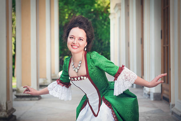 Beautiful woman in green medieval dress doing curtsey Beautiful young woman in green medieval dress doing curtsey outdoor curtseying stock pictures, royalty-free photos & images